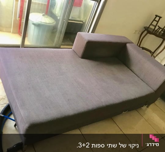 ספה אפורה עם דלי ומכשיר ניקוי על הרצפה
